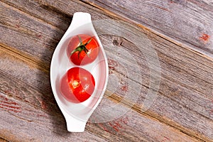 Two ripe red tomatoes in a dish