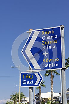 Two road signs with the names of settlements in the English and Greek languages and directions of traffic