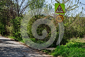 Two road signs on one post a sign for caution for children and a speed limit sign 40