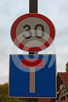 Two road signs on post against cloudy sky represent speed limit and deadlock sign. Balatonfoldvar, Hungary. Concept of road sign