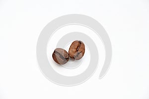 Two roasted coffee beans on white background