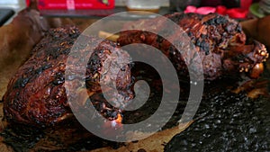 Two roasted mutton lamb leg covered with baking paper on baking tray