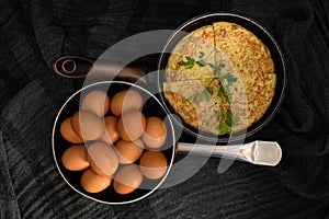 Two roasters in opposite directions with fresh eggs and an omelet divided into four parts