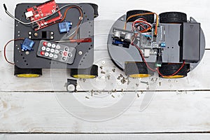 Two robot on wheels and elements necessary for the robot assembly. PCB, Servo Screwdriver