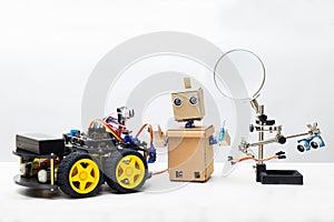 Two robots and parts for assembling a robot on a white background