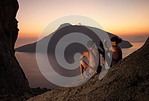 Two rock climbers having rest at sunset