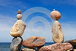 Two Rock zen pyramids of colorful pebbles on a beach on the background of the sea