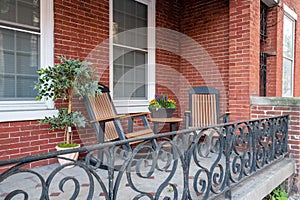 Two rocking chairs on a porch with an iron railing