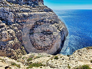 Two rocks kissing on a sunny day on blue sky and sea background. Sea water and rocks. A little tree grows on high mountain. Ocean