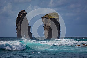 Two rocks in ocean water in rough sea waves