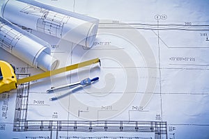 Two rolled blueprints tapeline compass with