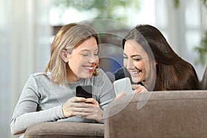 Two roommates talking about content on their smartphones photo