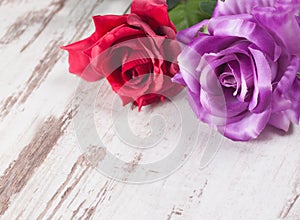 Two roses on wooden background