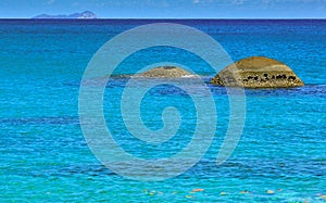 Two round rocks in the turquoise colored waters of the seychelles