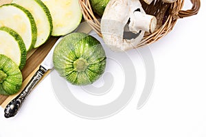 Two round zucchini cut in slices and wicker basket with vegetables