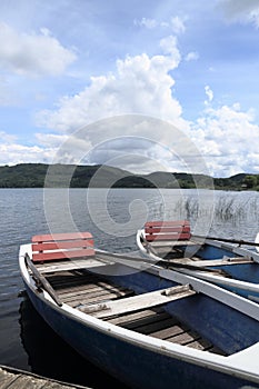 Two row boats at pier on lake photo