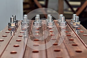 Two rows of bolts with washers and nuts fixed in busbars.