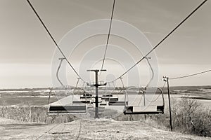 Two rows of deserted ski lift chairs