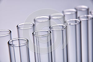Row of empty test tubes gray background
