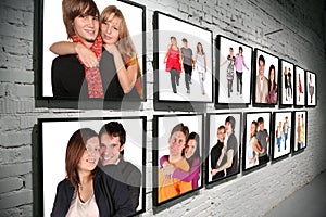 Two rows frames with people on brick white wall