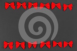 Two rows of red holiday bows on a black background