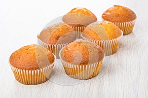 Two rows of small muffins on wooden table