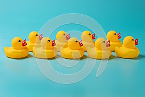 Two rows of yellow plastic ducks on a blue background