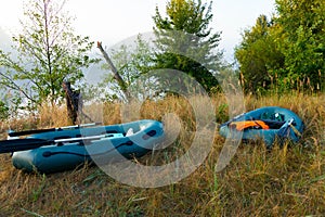 Two rubber boats with fishing tackle in the early morning during the fog, parked on the banks of the river