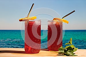 Two rum cocktails with cranberry juice on the tropical beach.