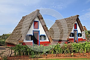 Two rural houses with triangular thatched roof