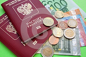 Two Russian foreign passports and euro notes of various denominations and Eurocent on a green background closw up top view