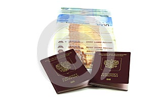 Two Russian passports with a bunch of rubles in denominations of five, two and one thousand rubles. The concept of immigration,