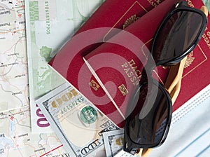 Two Russian passports are on the card and dollar and euro bills. On top of the passports are black sunglasses. The concept of