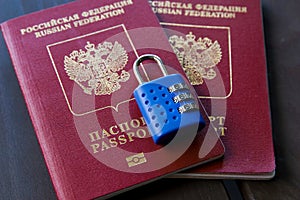 Two Russian passports locked to padlock. Symbol of anti-Russian sanctions