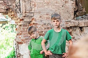 Two sad and unhappy brothers in a destroyed and abandoned buildi