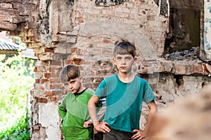 Two sad and unhappy brothers in a destroyed and abandoned building, staged photo