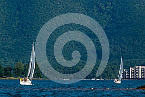 Two sail boats at the lake by the mountain