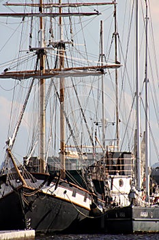 Two sailing ships are moored to each other at the pier