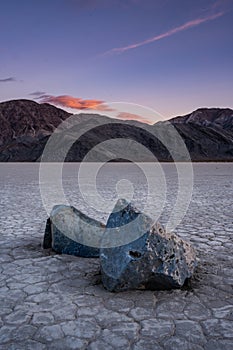 Two Sailing Stones Mimic The Distant Mountains At Sunset