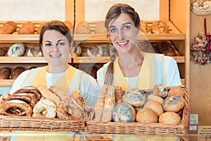 Two salesladies in bakery with basket of bread