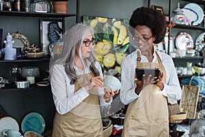 Two saleswomen using digital tablet for receiving goods