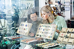 Two saleswomen working behind glass of jewelry shop