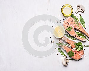 Two salmon steak, butter, pepper and salt, lemon, herbs border ,place for text wooden rustic background top view