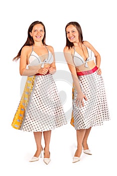 Two same women dressed in bikini and skirt smiles
