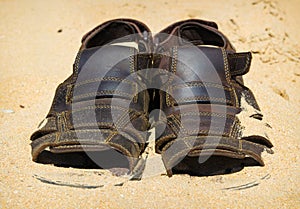 Two sandals to sprinkle with sands. Heat summer background