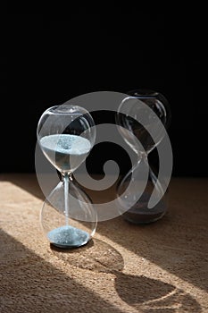 Two sandglasses on the black background