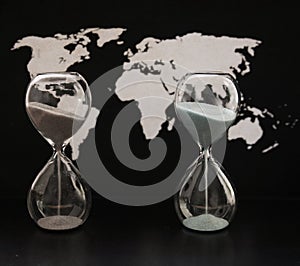 Two sandglasses, world political map, time passing