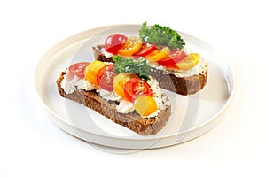 Two sandwiches with soft cheese and tomatoes