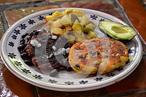 Two savory black bean and potato pancakes served on a plate with angua a la cocina, mexican food background image photo