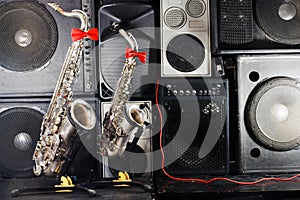 Two saxophones on music studio equipments background